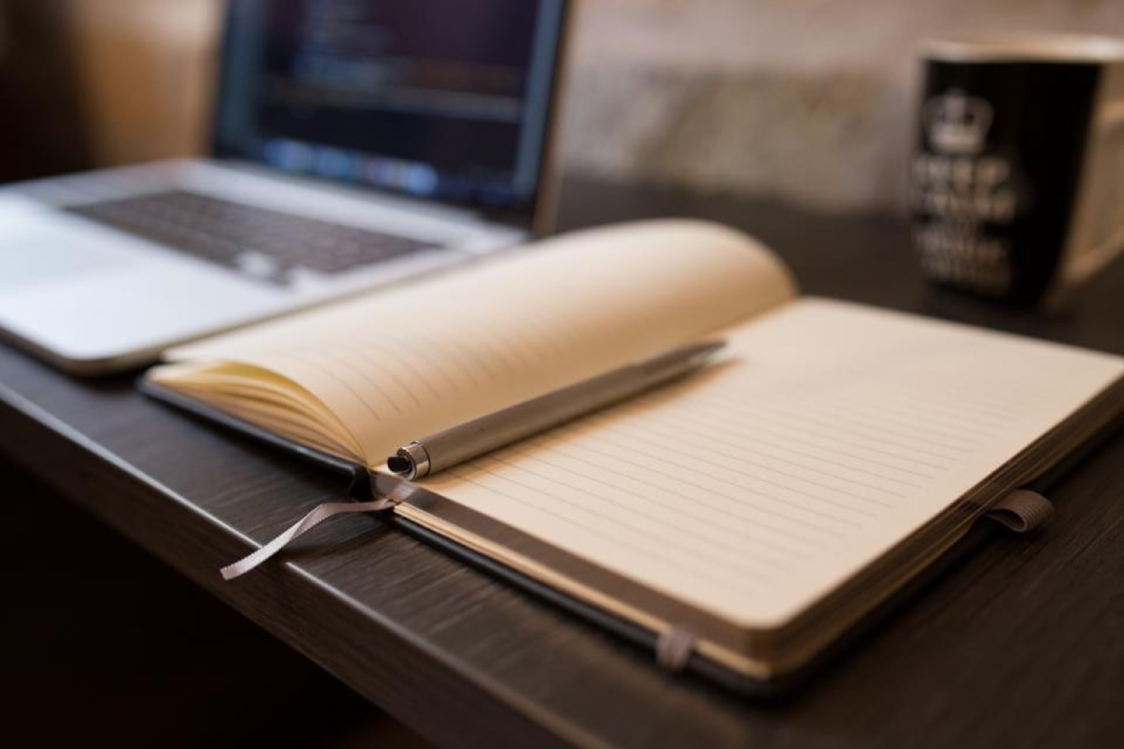 Carnet ouvert à côté d’un ordinateur portable